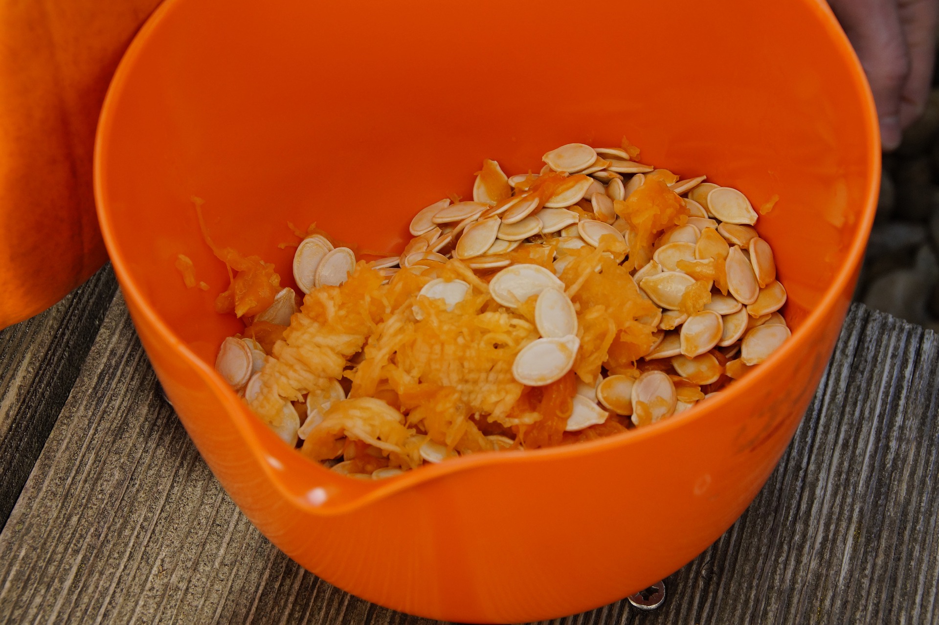 orange bowl full of pumpkin seeds